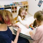 课后辅导 Children in a kindergarten engage in art activities guided by a teacher.
